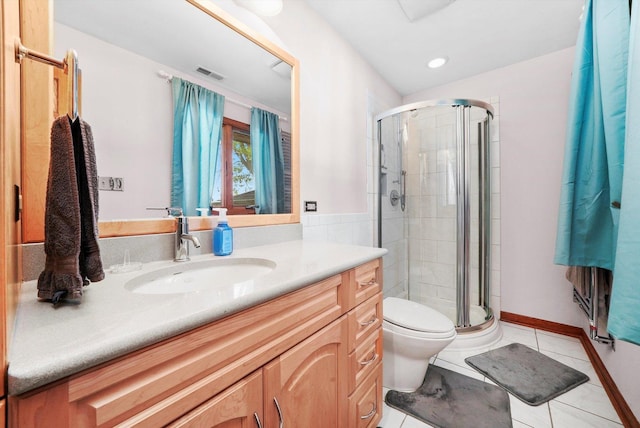 full bathroom featuring a stall shower, vanity, tile patterned floors, and toilet