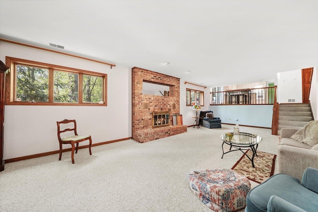 carpeted living room featuring baseboards, a brick fireplace, and stairs