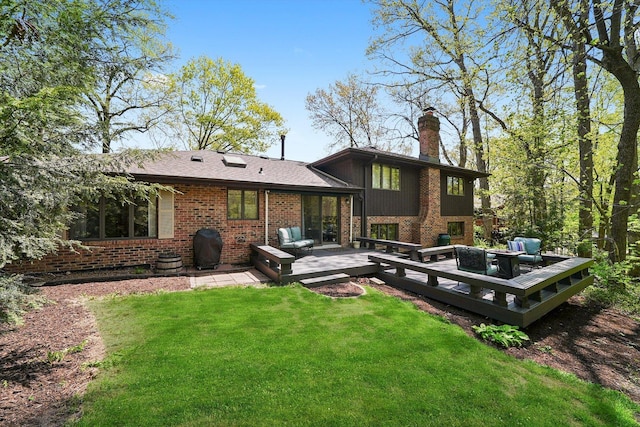 back of property featuring a chimney, brick siding, a lawn, a deck, and outdoor lounge area