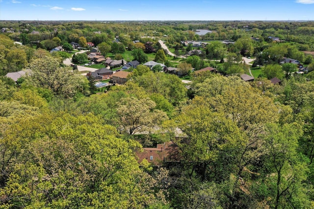 aerial view of property and surrounding area with a heavily wooded area