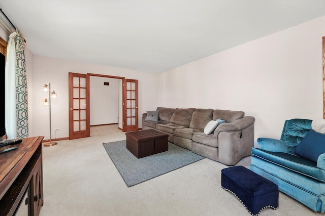 carpeted living area with french doors and baseboards