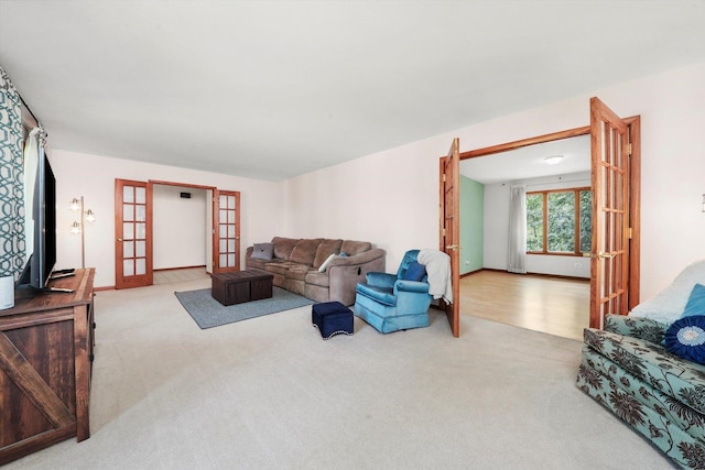 carpeted living room with french doors and baseboards