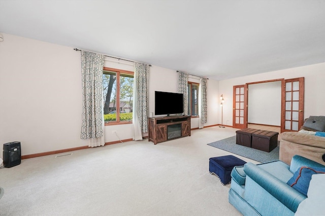 carpeted living room featuring baseboards