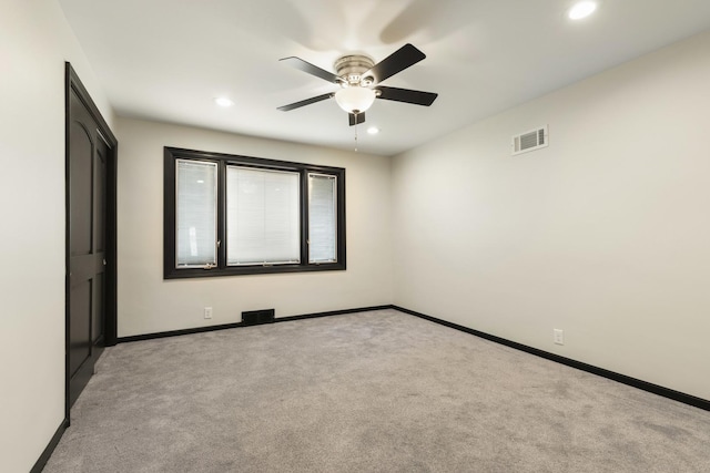 unfurnished room featuring visible vents, a ceiling fan, baseboards, and light carpet