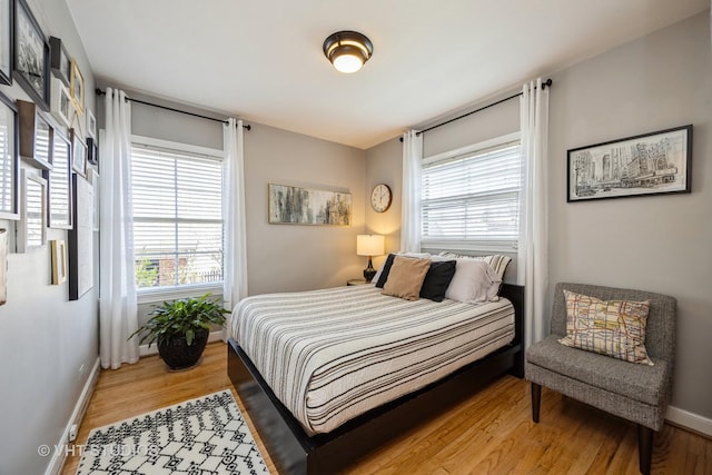 bedroom with light wood finished floors and baseboards