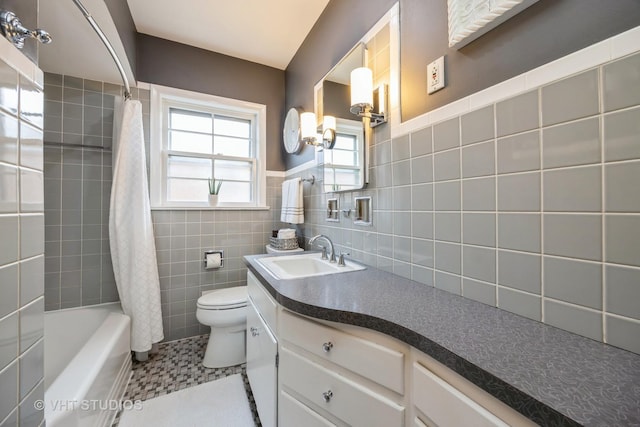 full bath featuring vanity, tile walls, toilet, tile patterned flooring, and shower / bath combo with shower curtain