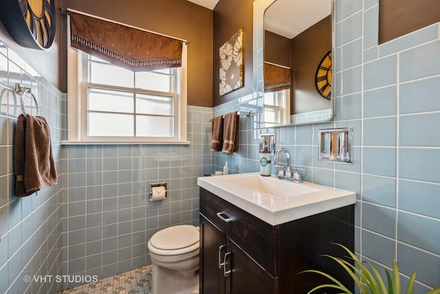 bathroom with tile walls, tile patterned floors, vanity, and toilet