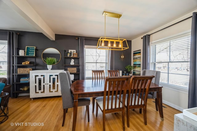 dining area with light wood-type flooring and a healthy amount of sunlight