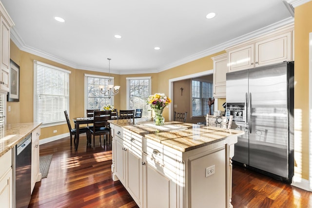 kitchen with stainless steel appliances, dark wood-style flooring, an inviting chandelier, and ornamental molding