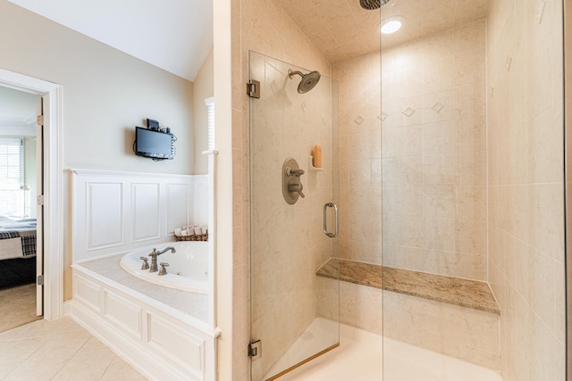 ensuite bathroom with vaulted ceiling, tile patterned floors, ensuite bath, a shower stall, and a bath