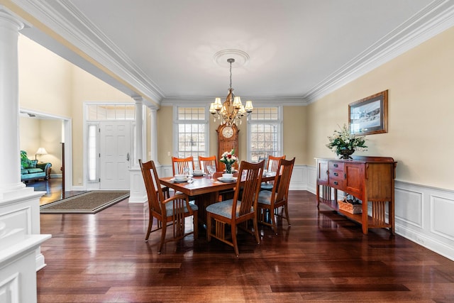 dining space featuring ornamental molding, decorative columns, a chandelier, and wood finished floors