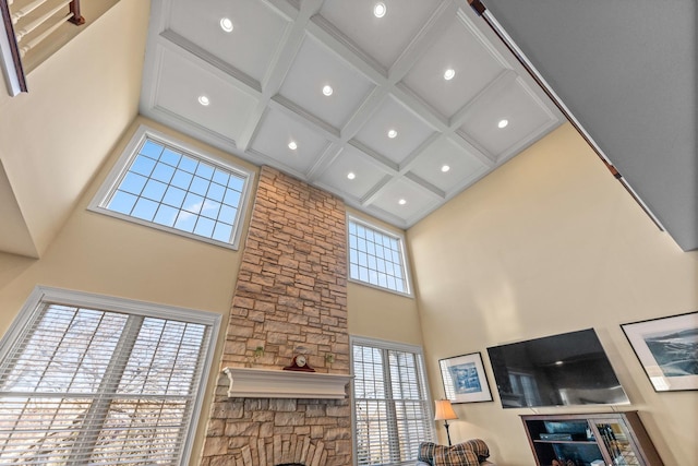living area with a high ceiling, beamed ceiling, and coffered ceiling
