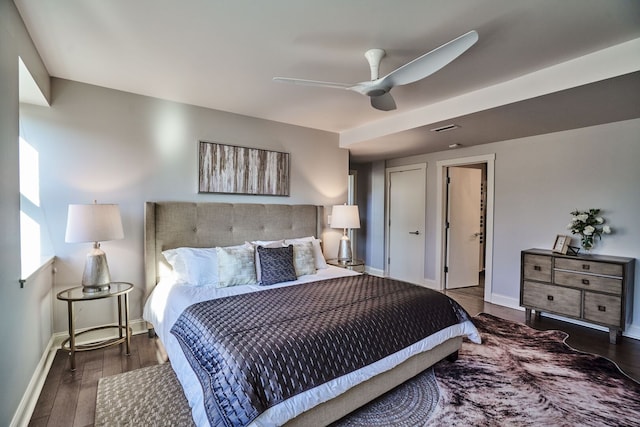 bedroom featuring baseboards, wood finished floors, visible vents, and ceiling fan