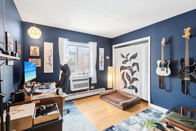 office area with an AC wall unit, baseboards, a baseboard heating unit, and wood finished floors