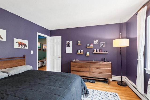 bedroom with a baseboard radiator and wood finished floors