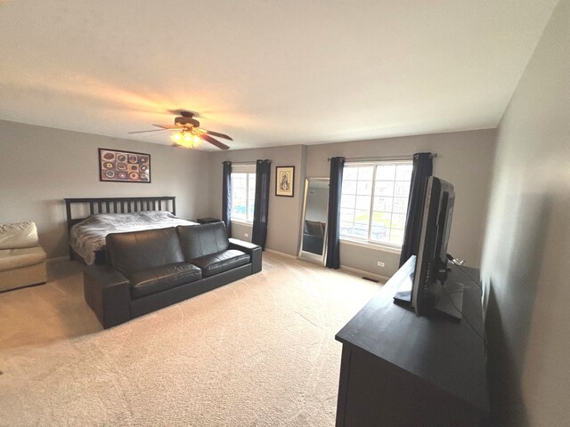 bedroom featuring light carpet, a ceiling fan, visible vents, and baseboards