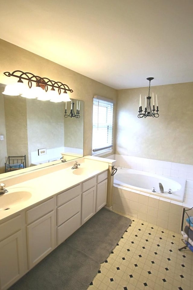 full bath featuring a bath, a notable chandelier, a sink, and double vanity