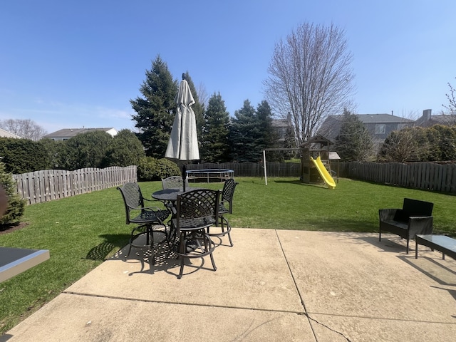 view of patio featuring a trampoline, a fenced backyard, and a playground