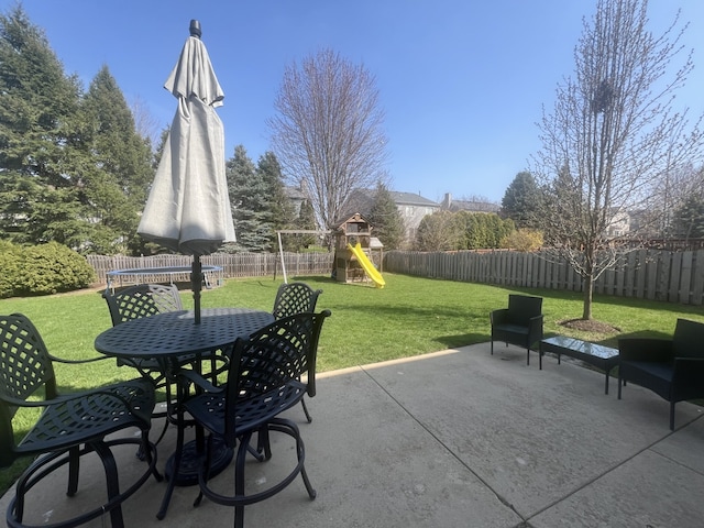 view of patio with a fenced backyard, outdoor dining space, and a playground