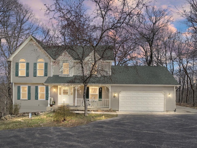 view of front of home with a garage, aphalt driveway, and covered porch