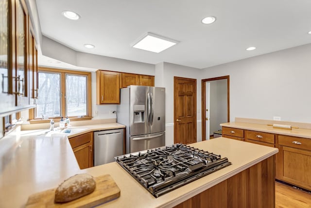 kitchen with brown cabinetry, light countertops, appliances with stainless steel finishes, and recessed lighting