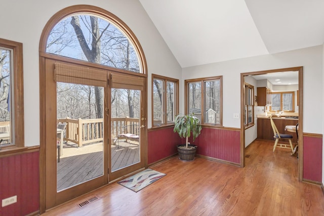 interior space featuring visible vents, high vaulted ceiling, and wood finished floors