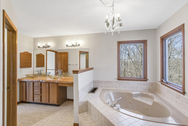 full bathroom with a chandelier, plenty of natural light, double vanity, and a tub with jets