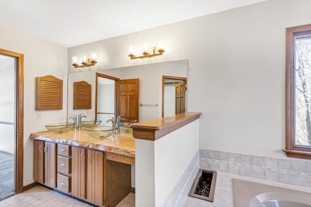 bathroom with a sink, double vanity, and a tub