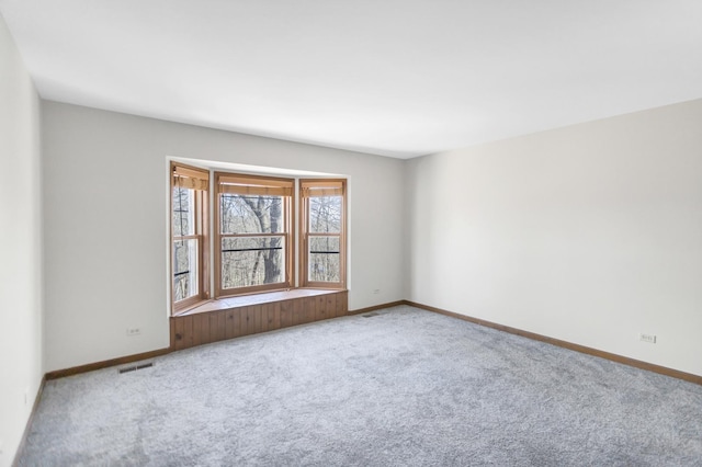 spare room with visible vents, baseboards, and carpet