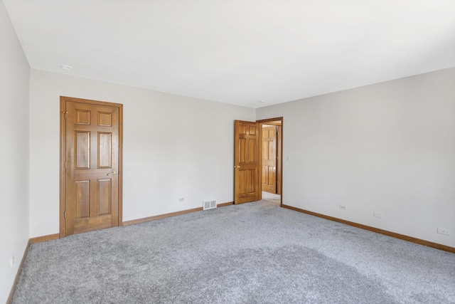 carpeted empty room featuring visible vents and baseboards