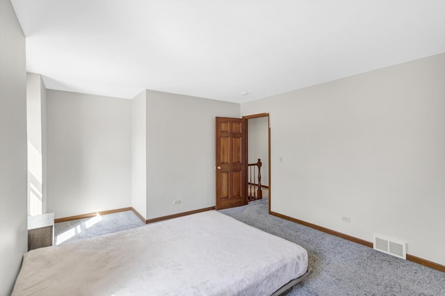 unfurnished bedroom with carpet flooring, visible vents, and baseboards