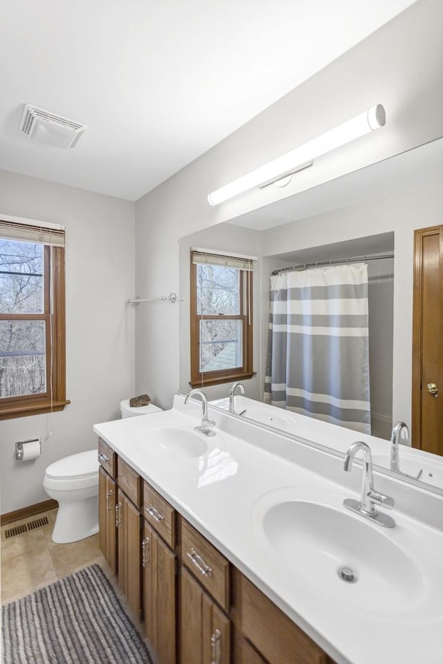 full bath with a sink, visible vents, toilet, and a healthy amount of sunlight