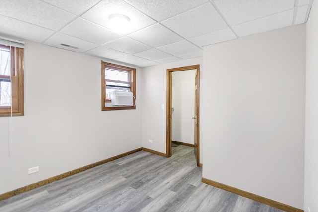 empty room with visible vents, baseboards, plenty of natural light, and wood finished floors