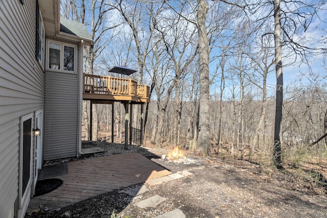 view of yard featuring a wooden deck and an outdoor fire pit