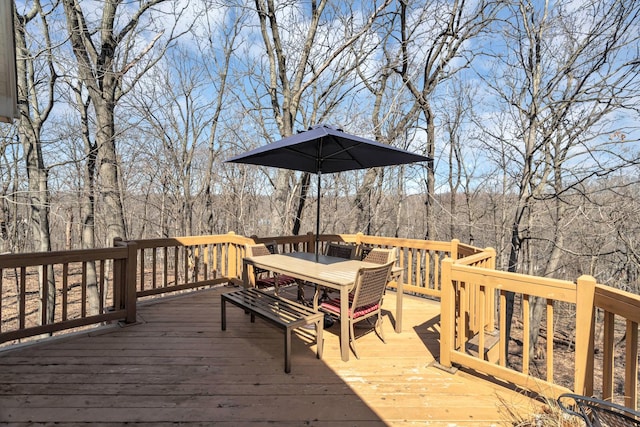 wooden deck featuring a wooded view and outdoor dining space