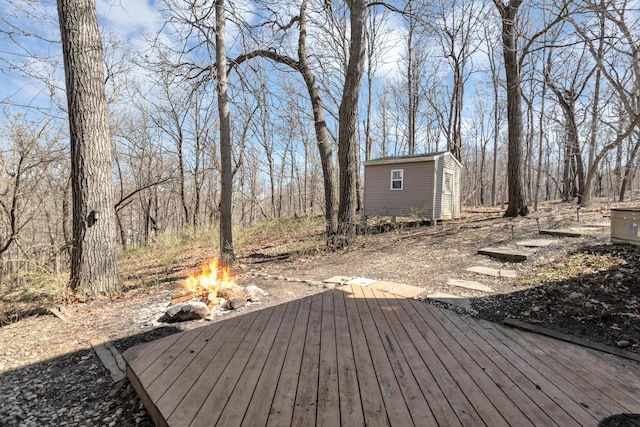 wooden deck featuring a fire pit and an outbuilding