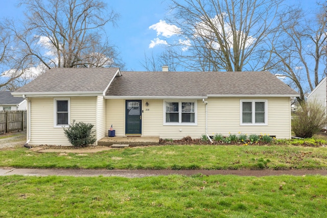 ranch-style home with a chimney, a front lawn, fence, and roof with shingles