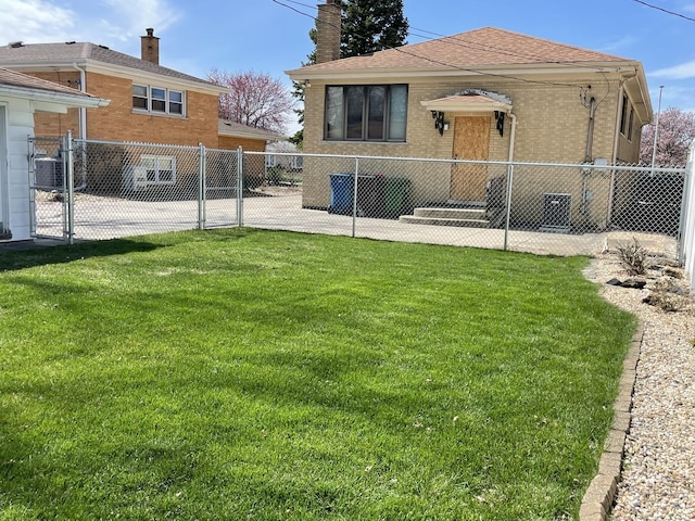 exterior space with a yard, brick siding, fence, and a chimney
