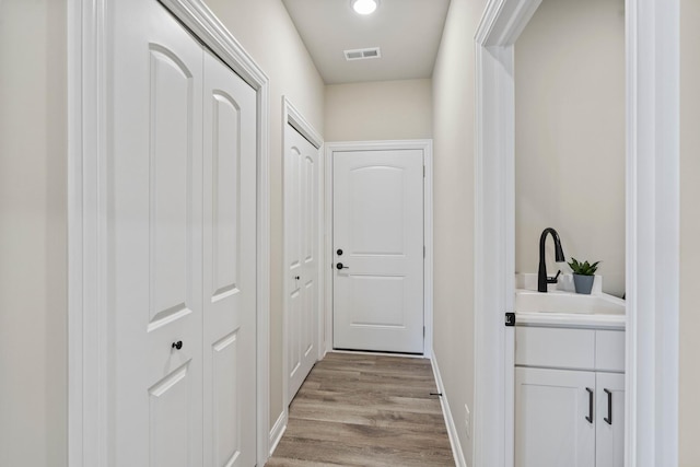 6367 Jasmine Ave, Portage, IN 46368 - doorway featuring light wood-style flooring, visible vents, baseboards, and a sink