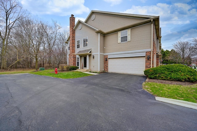 2136 Yale Cir, Hoffman Estates, IL 60192 - view of front of property featuring aphalt driveway, brick siding, a chimney, and an attached garage