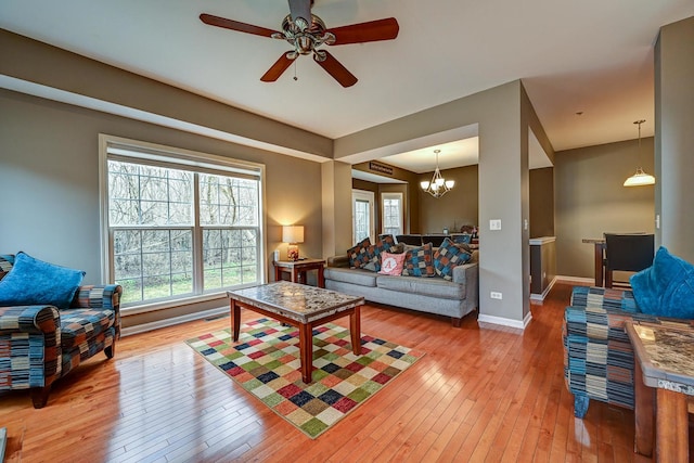 2136 Yale Cir, Hoffman Estates, IL 60192 - living room featuring baseboards, light wood-type flooring, and ceiling fan with notable chandelier