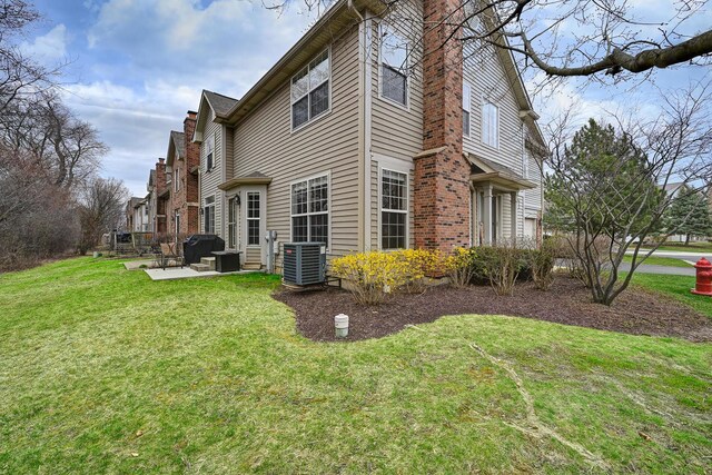 2136 Yale Cir, Hoffman Estates, IL 60192 - view of side of property featuring a yard, central AC unit, a chimney, and a patio