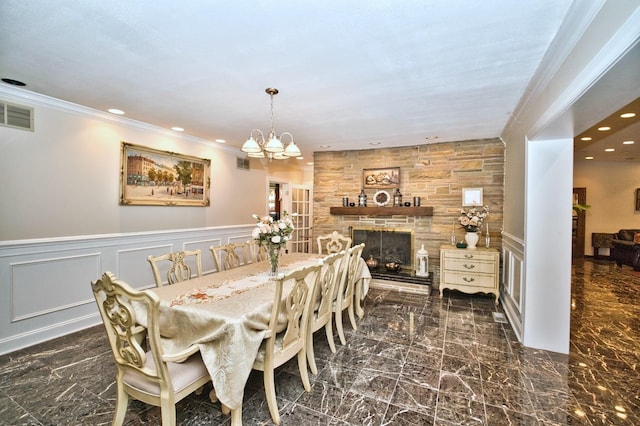 6776 N Laporte Ave, Lincolnwood, IL 60712 - dining room featuring a chandelier, a stone fireplace, recessed lighting, wainscoting, and a decorative wall
