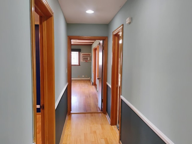 hall featuring light wood-style flooring and a baseboard heating unit