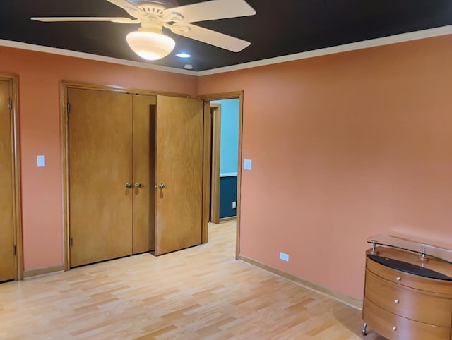 unfurnished bedroom with light wood finished floors, baseboards, ornamental molding, and ceiling fan