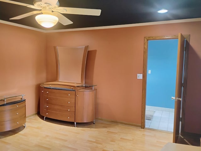 unfurnished bedroom featuring crown molding, baseboards, ceiling fan, and light wood-style floors
