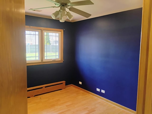 unfurnished room featuring ceiling fan, visible vents, baseboard heating, wood finished floors, and baseboards