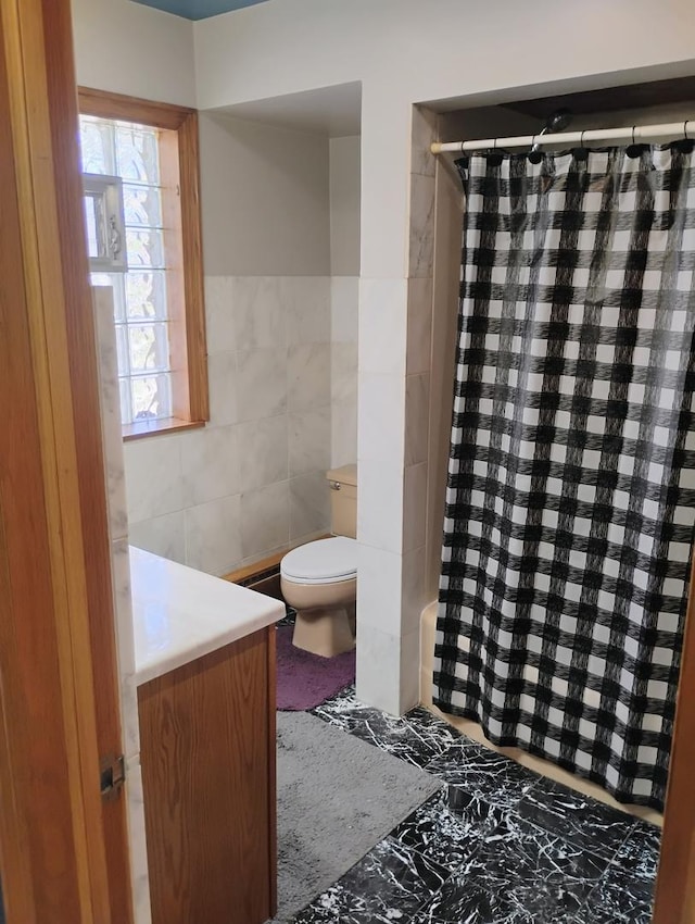 full bathroom with toilet, tile walls, and a shower with curtain