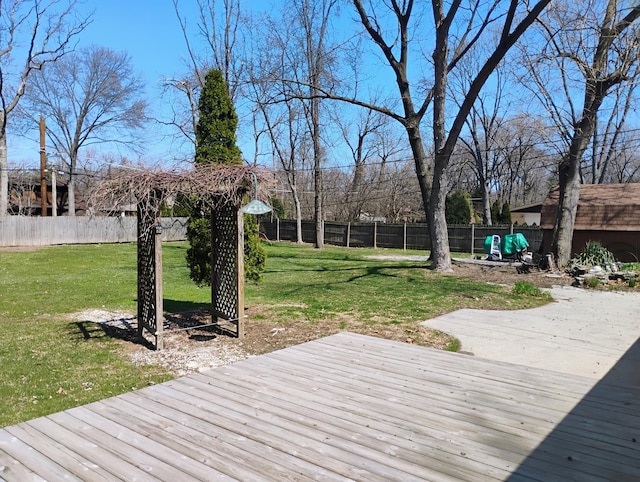 wooden deck featuring a fenced backyard, an outdoor structure, and a lawn