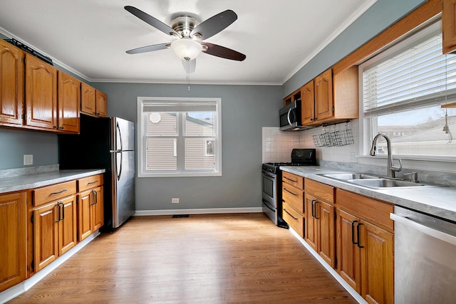 610 E Lemoyne Ave, Lombard, IL 60148 - kitchen with brown cabinetry, a sink, and appliances with stainless steel finishes